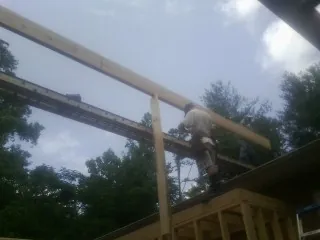 Carpenter setting a ridge beam over a new addition frame — Ice Dam Removal by Roofing Brothers in Demotte