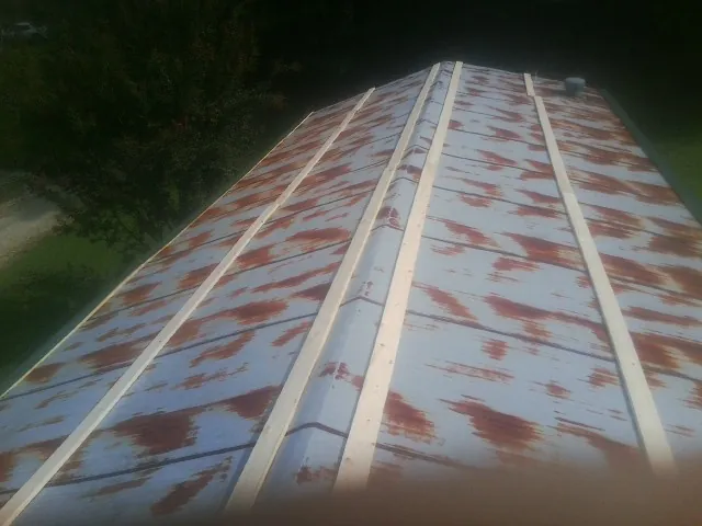 Rusted metal roof panels with new wood purlins before replacement — Storm Damage Roof Repair in Demotte by Roofing Brothers
