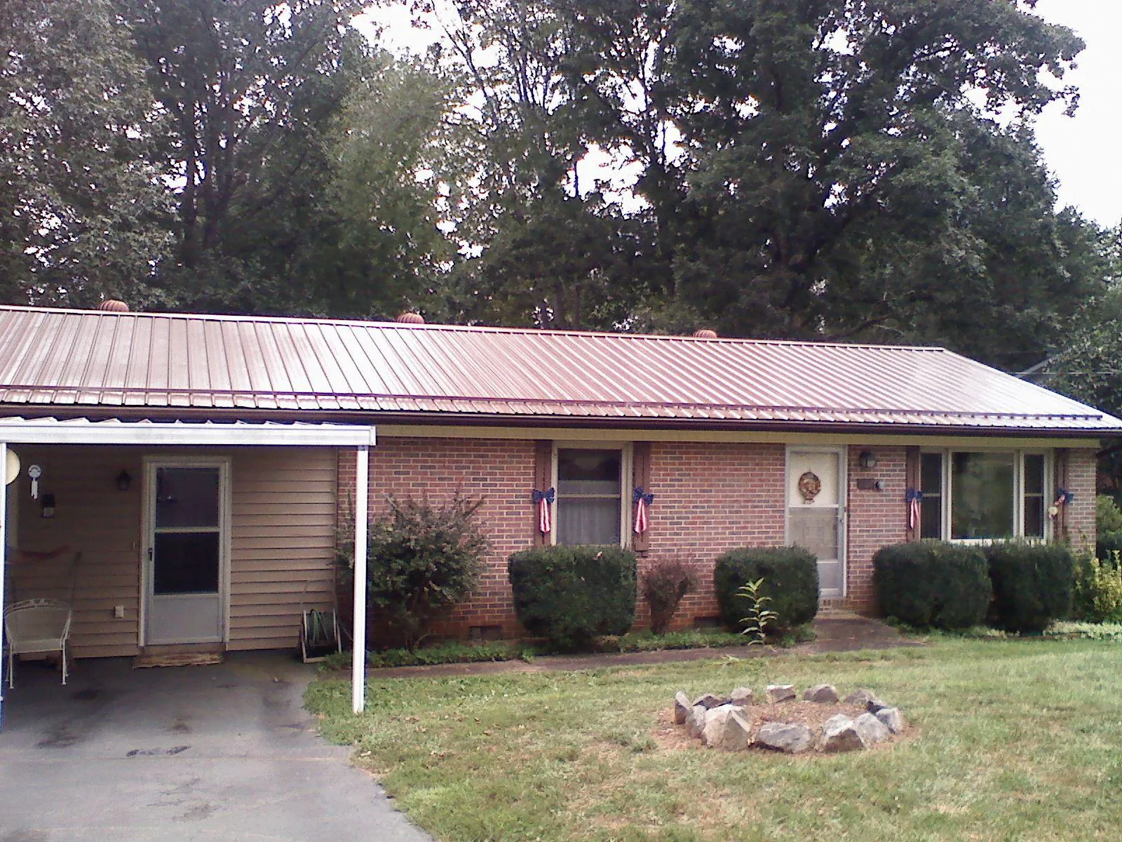 Bronze metal roof and carport on a brick ranch home — Roof Repair work by our crew in Demotte